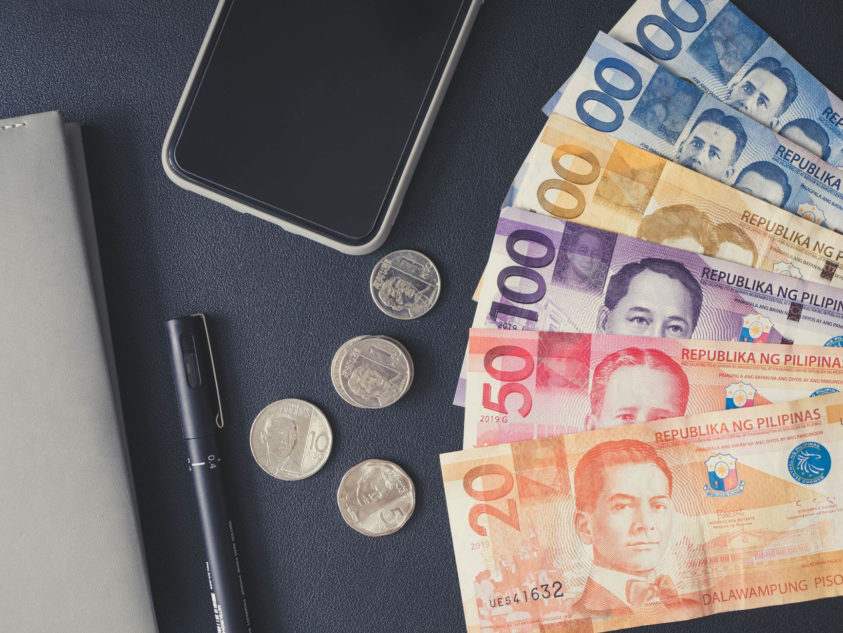 Philippine peso bills and coins on a table